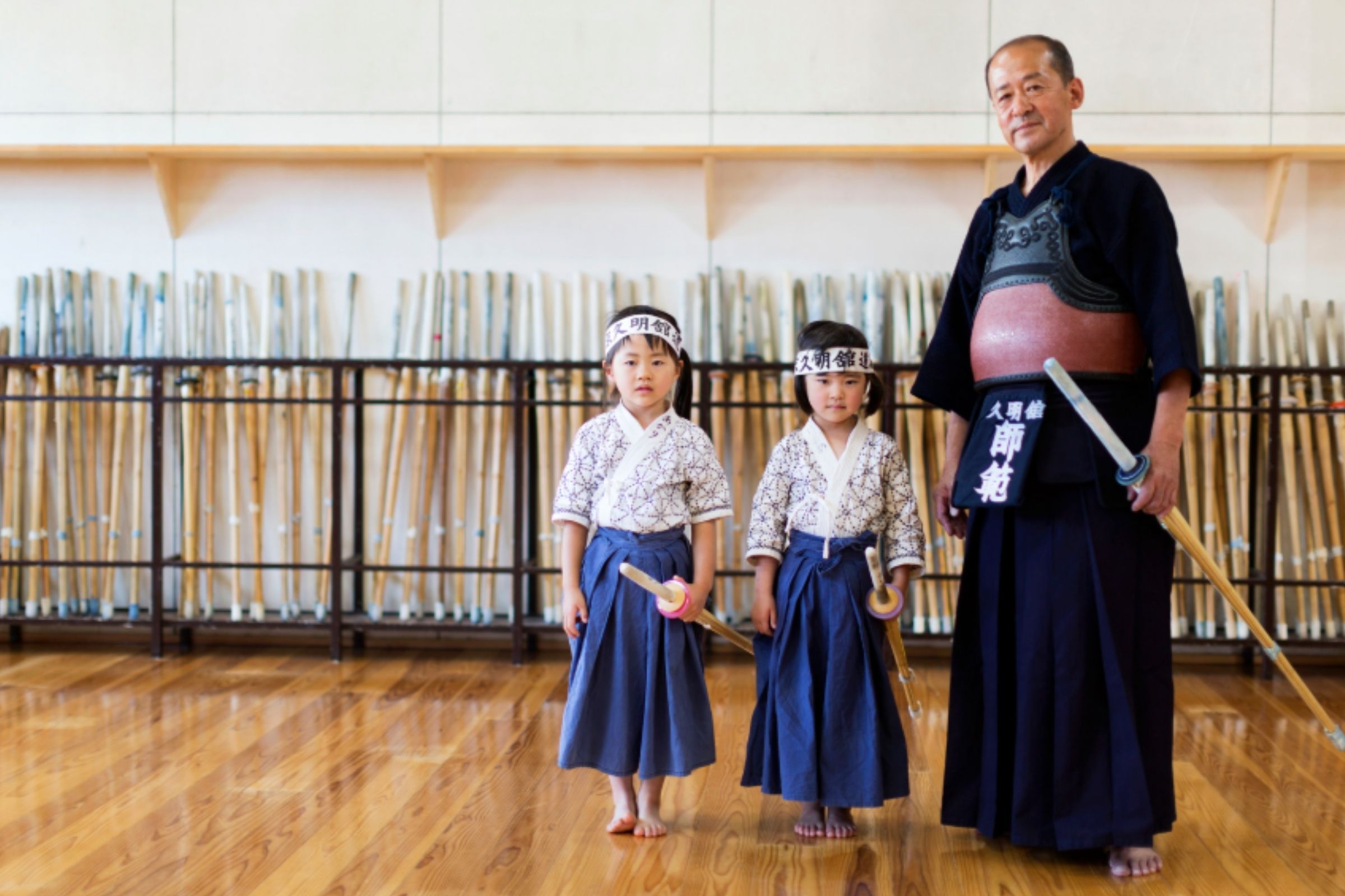 Tokyo Kyumeikan vyresnysis instruktorius su dviem mergaitėmis.